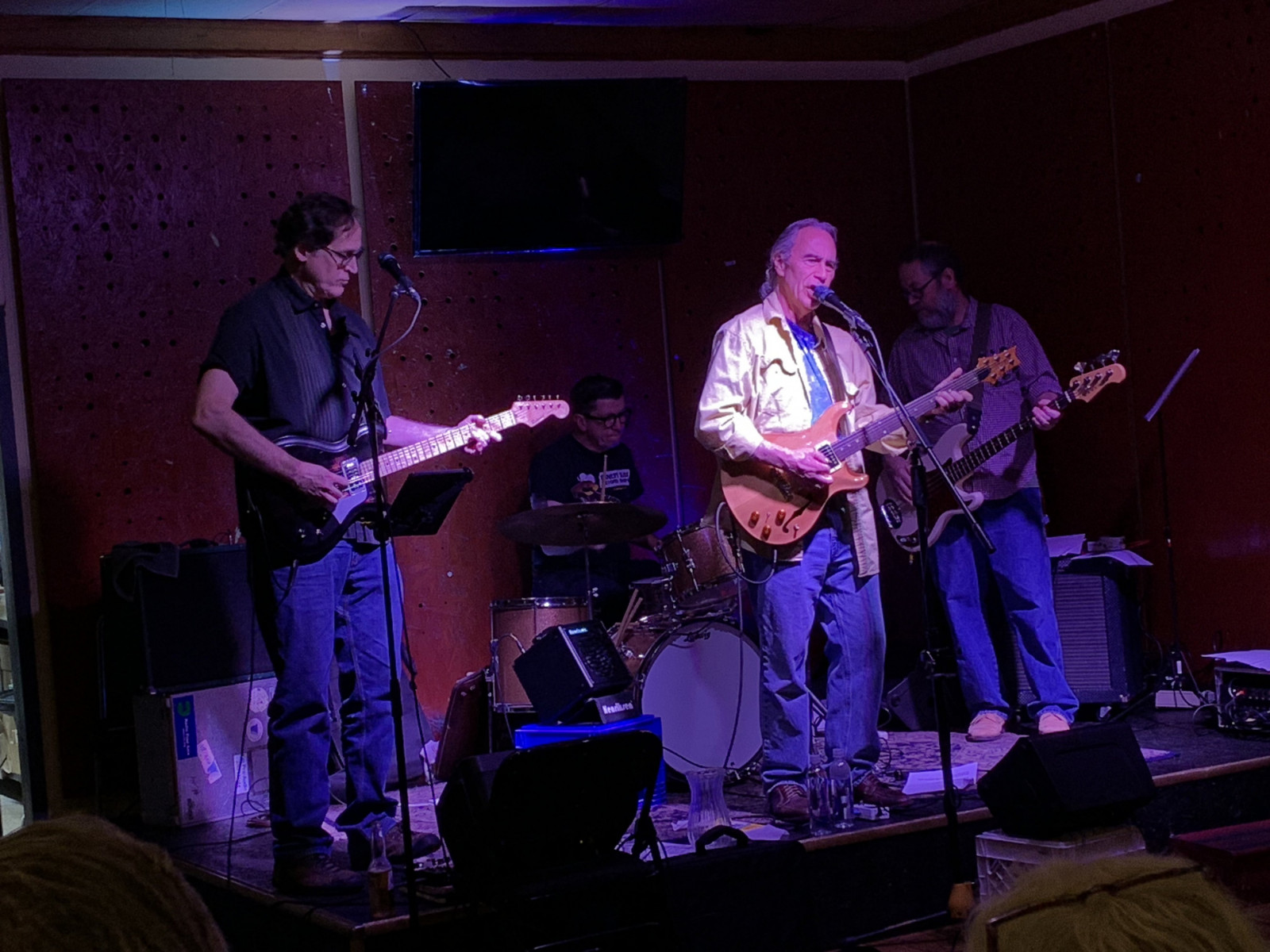 Joe Uehlein and his band perform on stage under purple lighting.